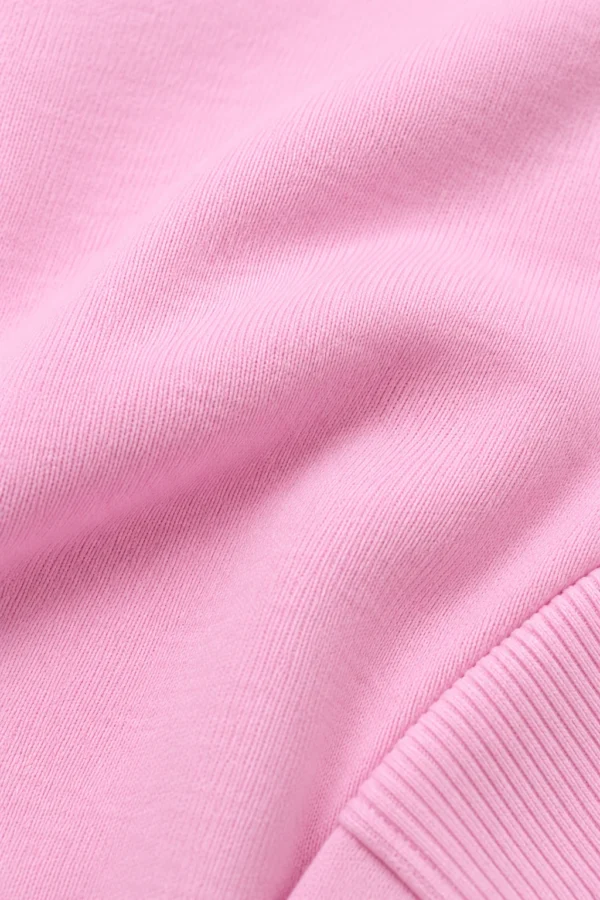 Pink zip-up hoodie and jogger set, illustrative fabric close-up